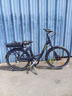 un vélo noir garé devant un mur bleu