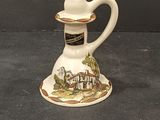 a small white pitcher with a picture of a house on it
