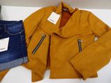 two pieces of clothing are sitting on a table next to a pair of jeans