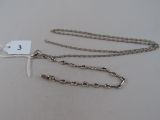 two silver chains with a tag attached to them on a table