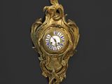 une horloge en or sur le mur avec un oiseau dessus