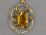 un gros plan d'un pendentif en or serti d'une citrine