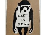 découpe au pochoir représentant un ours tenant une pancarte sur laquelle on peut lire « keep it real »