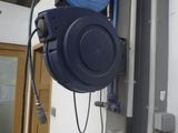 un tuyau bleu suspendu au mur d'un immeuble
