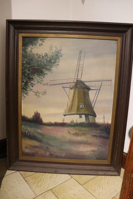 tableau représentant un moulin à vent, encadré, posé par terre à côté d'une chaise