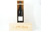 une bouteille de vin dans un coffret en bois sur une table