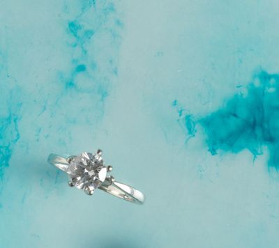 a diamond ring sitting on top of a blue surface