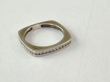 gros plan d'une bague en argent sur une surface blanche
