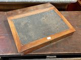 une boîte en bois contenant une pierre noire, posée sur une table