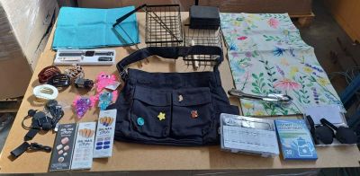 une table sur laquelle se trouvent de nombreux objets, notamment un sac à main et d'autres objets