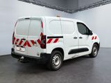 a white van with red and white stripes parked in a garage