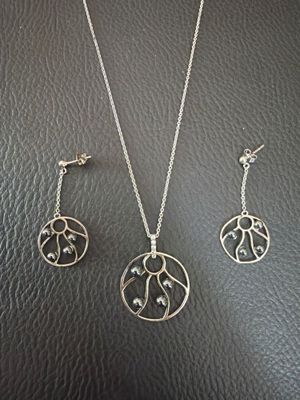 un gros plan d'un collier et de boucles d'oreilles posés sur une surface en cuir