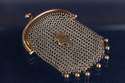 un gros plan d'un sac à main en métal posé sur une surface bleue
