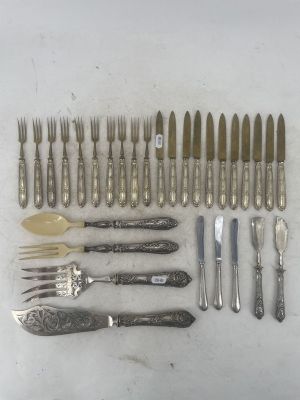 a lot of silverware on a table with knives and spoons