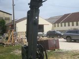 a crane that is sitting in the grass in front of a building