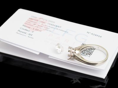 une bague posée sur un morceau de papier, à côté d'une autre bague