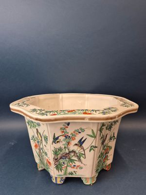 une image représentant un pot de fleurs en céramique orné d'oiseaux et de fleurs
