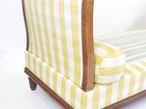 une chaise longue rayée jaune et blanche sur fond blanc