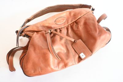 sac à main en cuir marron sur fond blanc, muni d'une bandoulière marron