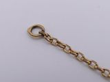 a close up of a gold chain on a white surface