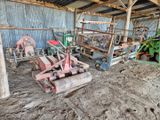 un tracteur qui est à l'abandon dans la boue, dans une grange