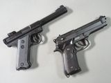 deux armes à feu posées l'une à côté de l'autre sur une table