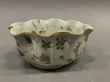 a white bowl with flowers on it on a table