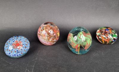four glass marbles sitting on top of a black surface
