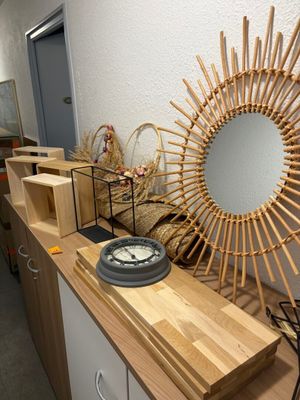 un miroir accroché au mur, à côté d'une étagère sur laquelle sont posés des paniers