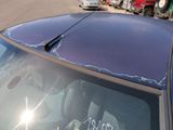 a car with a broken windshield that has a sticker on it