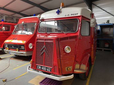 trois camions de pompiers rouges garés dans un garage