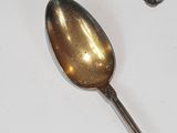 a silver spoon sitting on top of a white table