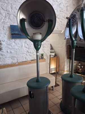 three green blow dryers sitting on top of each other in a room