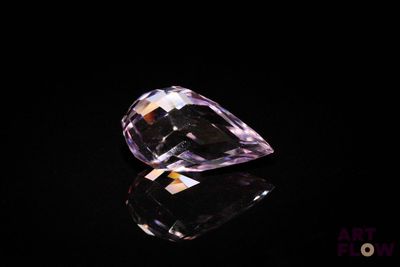 a close up of a purple diamond on a black surface
