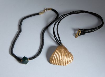 un collier orné d'un coquillage, posé sur une table