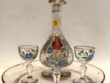 une carafe en verre et deux verres à vin posés sur un plateau
