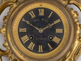 a gold clock with roman numerals on the face