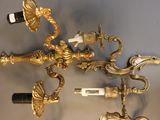 a gold wall sconce with a bottle of wine on top of it