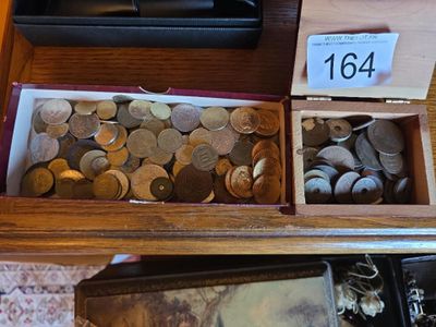 a lot of coins in a wooden box on a table
