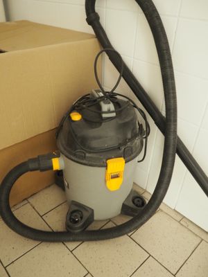 un aspirateur posé sur le sol à côté d'une boîte