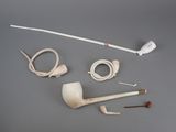 a pipe, a pipe holder, a pipe and a pipe holder on a table
