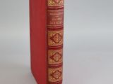 a red book that is sitting on a white surface