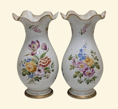 two vases with flowers painted on them sitting on a table