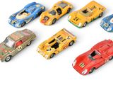 several toy cars are lined up in a row on a white surface