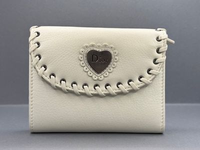 un sac à main blanc orné d'un cœur sur le devant et d'une chaîne qui l'entoure