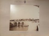 une vieille photo d'un pont enjambant une rivière, avec un château en arrière-plan