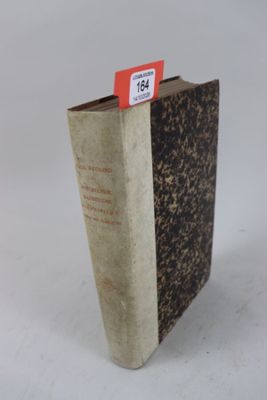 un livre portant une étiquette rouge, posé sur une surface blanche