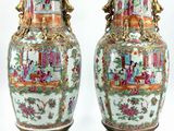 pair of oriental vases on stands with asian scenes on them