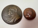 une pièce sur laquelle figure l'effigie d'un homme, à côté d'une pièce sur laquelle figure l'effigie d'un homme