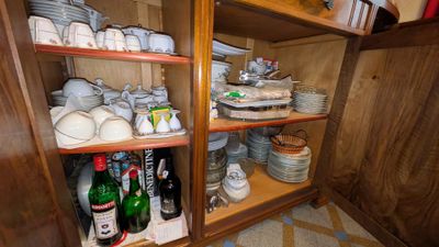 de nombreuses assiettes et tasses sur les étagères de la cuisine